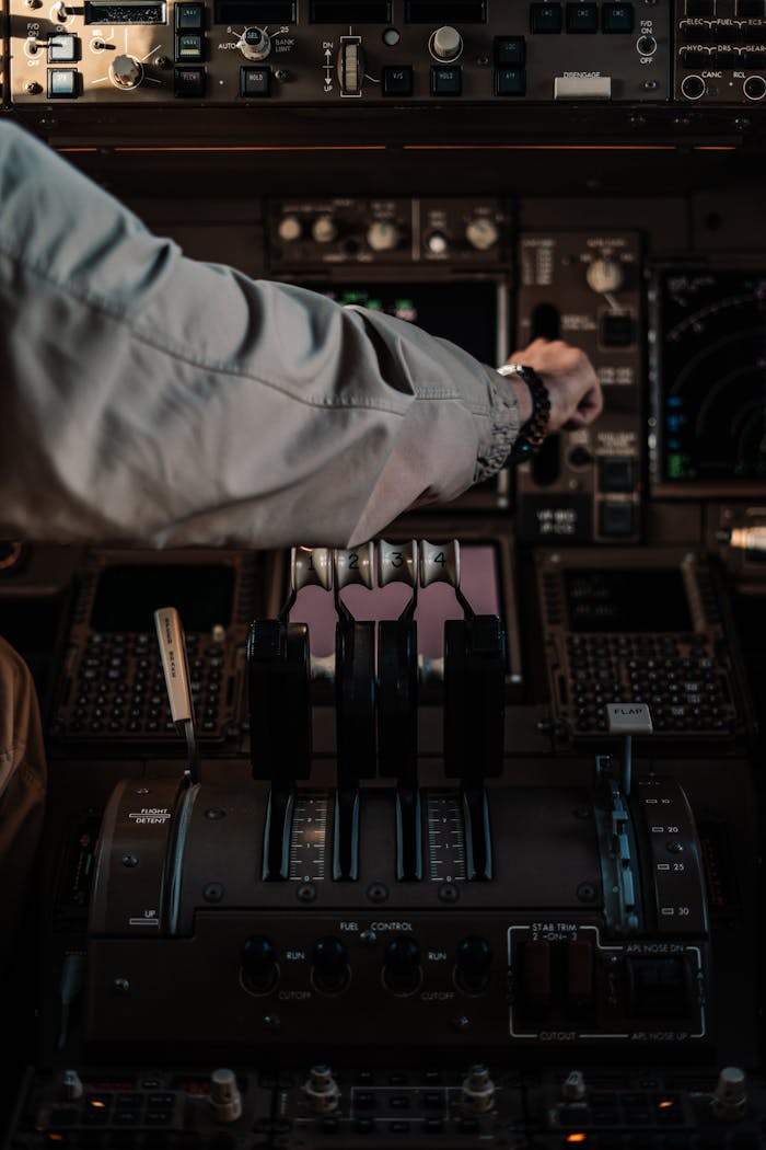 Close-up of a pilot's hand operating the cockpit controls of an airplane, showcasing aviation technology and precision.